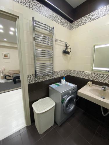 a bathroom with a washing machine and a sink at Apartment Vake in Tbilisi City