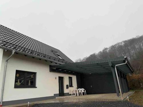 a building with a garage with two tables and chairs at Traumhaftes Ferienhaus – perfekt für Familien in Schlüchtern