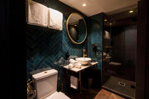 a bathroom with a toilet and a sink and a mirror at City Hotel Haarhuis, World Hotels Crafted Collection in Arnhem