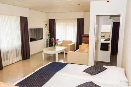 a bedroom with a bed and a living room at Best Western Hotel Slenaken in Slenaken