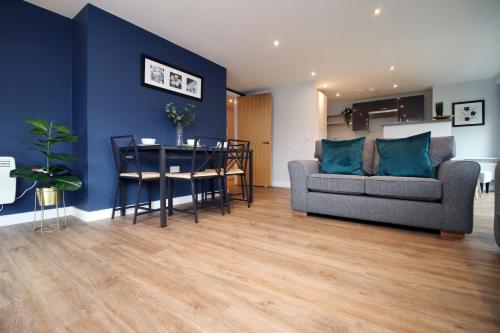 a living room with a couch and a table at Violets Corner Luxury Swindon Town Apartment Great Location In The South West in Swindon