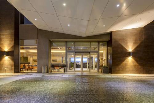 een lege lobby van een gebouw met glazen deuren bij La Quinta by Wyndham Santiago Aeropuerto in Santiago