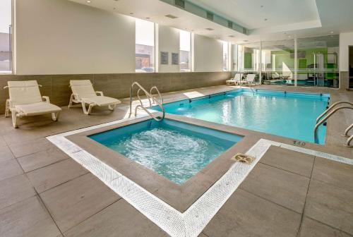 a large swimming pool in a hotel room with a pool at La Quinta by Wyndham Santiago Aeropuerto in Santiago