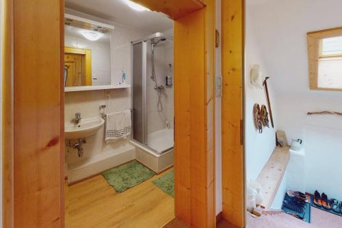 a bathroom with a shower and a sink and a tub at Julach Haus Apartment in Längenfeld