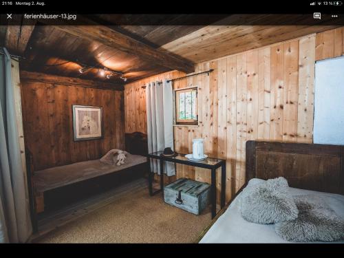 a bedroom with wooden walls and a bed and a table at Knottn Hüttl, St. Pankraz/Ulten, Nähe Meran in San Pancrazio dʼUltimo