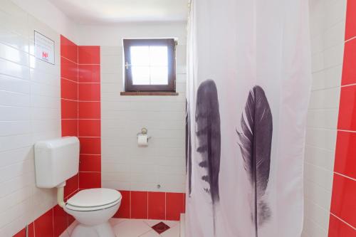een badkamer met een toilet en veren op het douchegordijn bij Apartment Adriana on peaceful location with pool in Pula