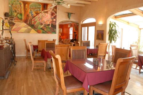 阿爾伯克基的住宿－Casas de Suenos Old Town Historic Inn, Ascend Hotel Collection，一间带桌椅和绘画的用餐室