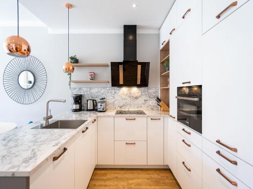 a kitchen with white cabinets and a sink at Strandresidenz Else Marie App 1 4 in Ahlbeck