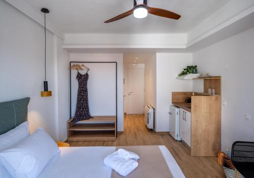 um quarto com uma cama e um vestido pendurado num espelho em Aiora Suites by Booking Kottas em Psakoudia