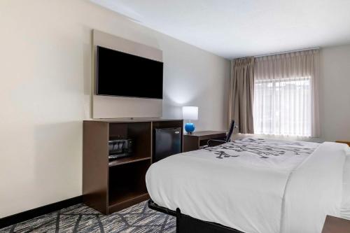a hotel room with a bed and a flat screen tv at Sleep Inn & Suites Augusta West Near Fort Eisenhower in Grovetown