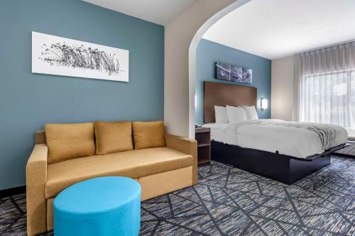 una camera d'albergo con letto e divano di Sleep Inn & Suites Augusta West Near Fort Eisenhower a Grovetown