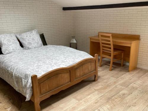 a bedroom with a bed and a desk and a chair at La bergerie in La Bruyère