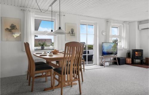 a dining room with a table and chairs and a television at 2 Bedroom Cozy Home In Lemvig in Lemvig