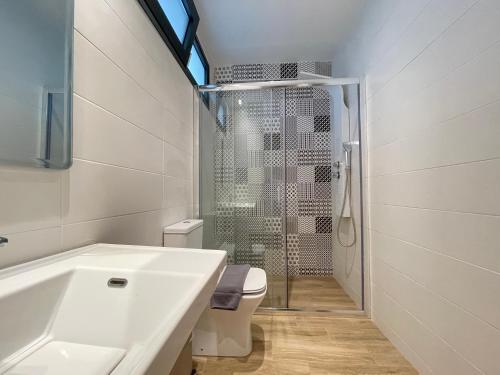 a bathroom with a sink and a toilet and a shower at Villa Oleandra by the sea in Polykhrono