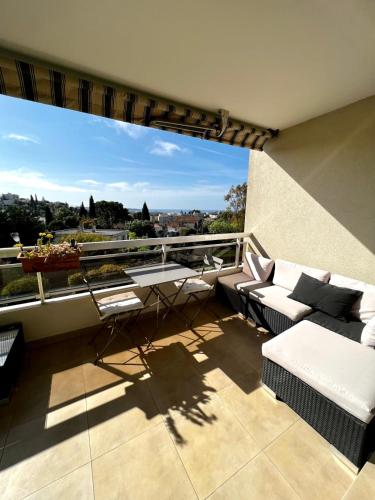 d'un balcon avec vue doté d'un canapé et d'une table. dans l'établissement Antibes Maeva sea view swimming pool air conditioning and parking, à Antibes