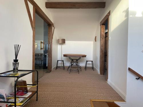 - un couloir avec une table et des chaises dans la chambre dans l'établissement Les Quartiers d'Annelise, à Verdun-sur-Meuse