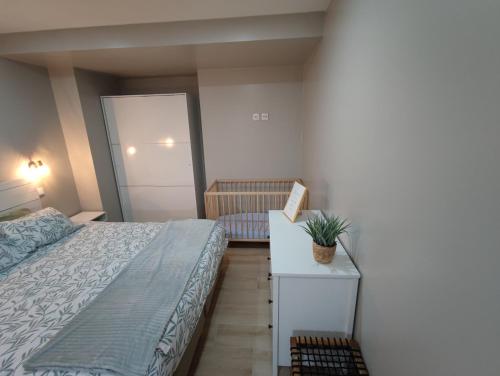1 dormitorio con cama y mesa con maceta en Casa da Eirinha - Azibo en Macedo de Cavaleiros