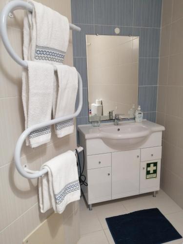 a bathroom with a sink and a mirror and towels at PENICHE - Guest House Casa das Estelas in Peniche