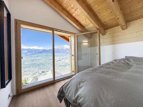 una camera con un letto e una grande finestra di Chalet Commaraf! - Swiss Alp 4 Vallees ad Agettes