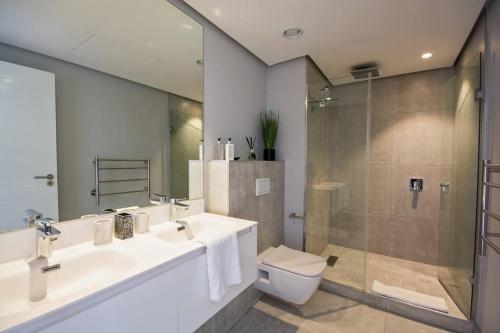 a bathroom with a toilet and a sink and a shower at Magnificent penthouse with breathtaking views in Cape Town