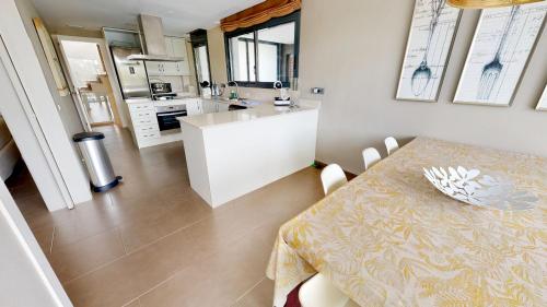 uma cozinha e sala de jantar com uma mesa e uma mesa e cadeiras em Nirvana em L'Ampolla