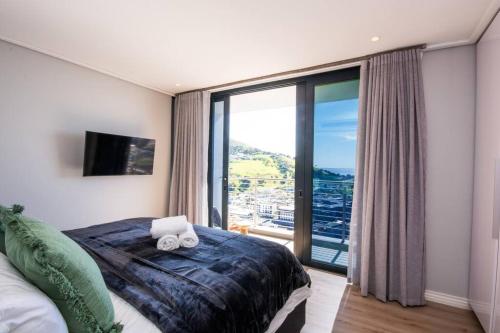 a bedroom with a bed and a large window at Magnificent penthouse with breathtaking views in Cape Town