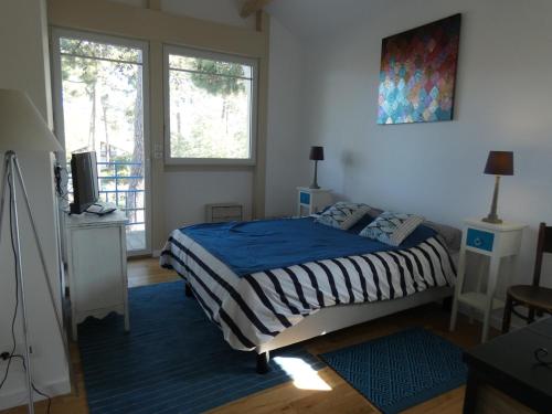 une chambre avec un lit avec une couette bleue dans l'établissement Villa moderne 4 chambres, piscine chauffée, Wi-Fi, proche plage et commerces, Arcachon - FR-1-374-147, à Arcachon