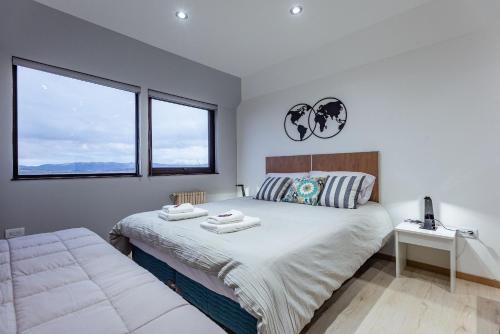 ein Schlafzimmer mit einem Bett mit zwei Handtüchern darauf in der Unterkunft Gente del Sur - Finisterre B in Ushuaia