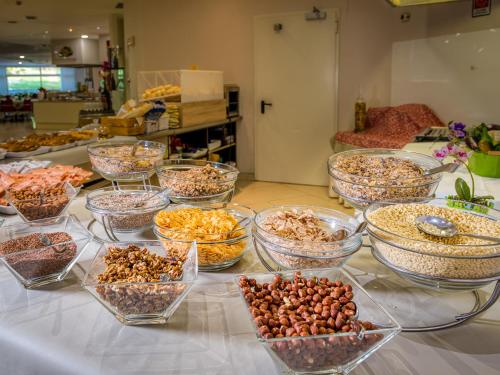 a table with many bowls of food on it at Parc Hotel in Peschiera del Garda