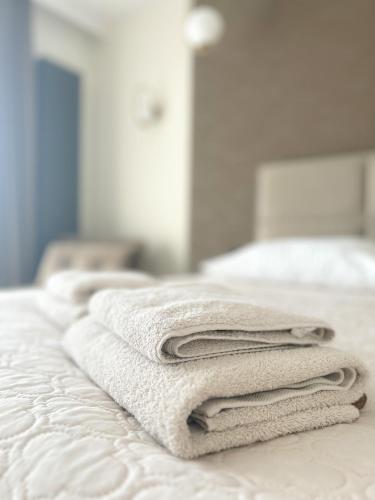 een stapel handdoeken bovenop een bed bij BUNASTA Apartments in Białystok