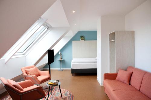 ein Wohnzimmer mit einem Sofa, 2 Stühlen und einem Bett in der Unterkunft greet Wien City Nord in Wien
