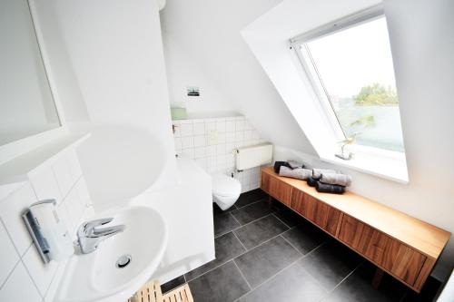 a bathroom with a sink and a window at Haus Blümlein Wangerooge in Wangerooge