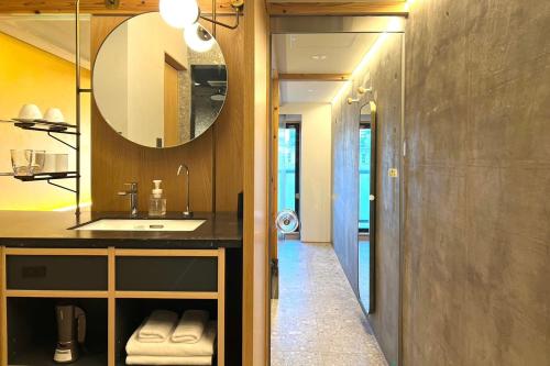 a bathroom with a sink and a mirror at Kyoto ITOYA Hotel Mon 京都糸屋ホテル モン in Kyoto