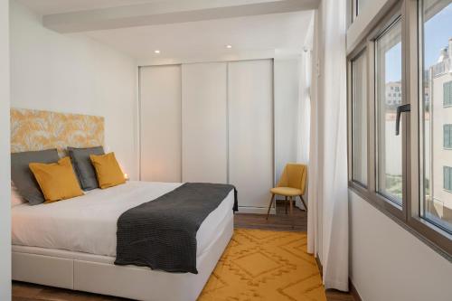 a bedroom with a bed and a large window at Alegria Flat by An Island Apart in Funchal