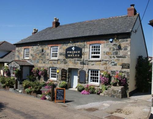 an old stone building with flowers in front of it at The Prince of Wales in Helston