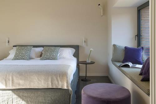 a bedroom with a bed with a purple stool at Dimora Cottanera in Castiglione di Sicilia
