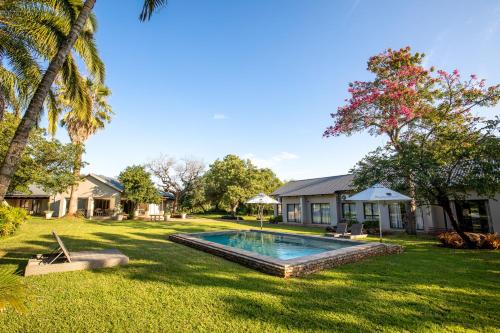 馬里蘭的住宿－Hamiltons Lodge & Restaurant，一个带游泳池和房子的后院