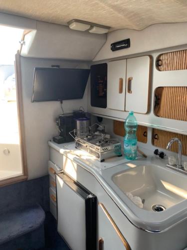 a small kitchen with a sink and a stove at Bed & Boat Porto Rotondo in Marinella