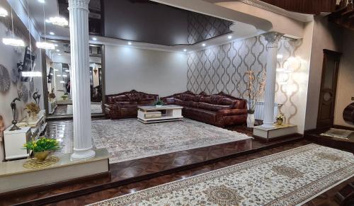 a living room with leather couches at Sultan Saray in Osh