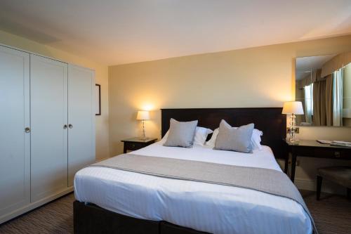a bedroom with a large white bed and a desk at St George's Hotel - Llandudno in Llandudno