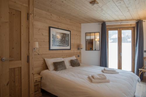 a bedroom with a bed with towels on it at Chalet Makalu in Les Gets