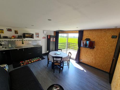 eine Küche und ein Esszimmer mit einem Tisch und Stühlen in der Unterkunft Au Saule en Seine in Saint-Wandrille-Rançon