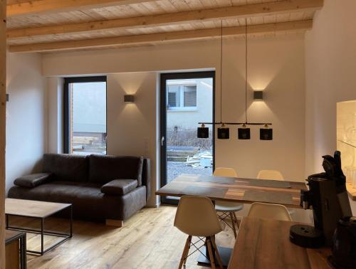 ein Wohnzimmer mit einem Sofa und einem Tisch in der Unterkunft Filder-Appartements in Filderstadt