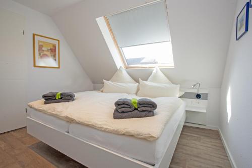 um pequeno quarto com uma cama com toalhas em Swantje in Residenz zum Südstrand em Borkum