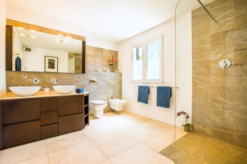 a bathroom with two sinks and a shower at Casa Pura - Luxuriöses Ferienhaus mit Meerblick in Llucmajor