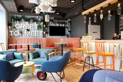 a restaurant with colorful chairs and a bar at greet Wien City Nord in Vienna