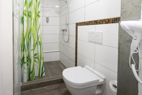 a white bathroom with a toilet and a shower at Cannstatter Hotel in Stuttgart