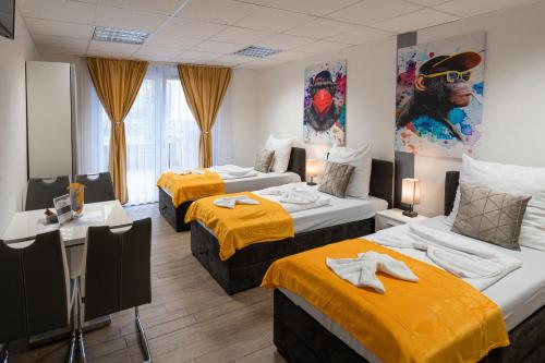 una camera d'albergo con tre letti con lenzuola gialle di Cannstatter Hotel a Stoccarda