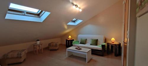 uma sala de estar no sótão com um sofá e uma janela em Apartamento San Bartolo em Barreiros
