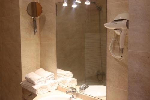 uma casa de banho com um lavatório e um chuveiro com toalhas em Apartamento San Bartolo em Barreiros